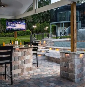 Custom outdoor kitchen design with built-in lighting and stone finishes